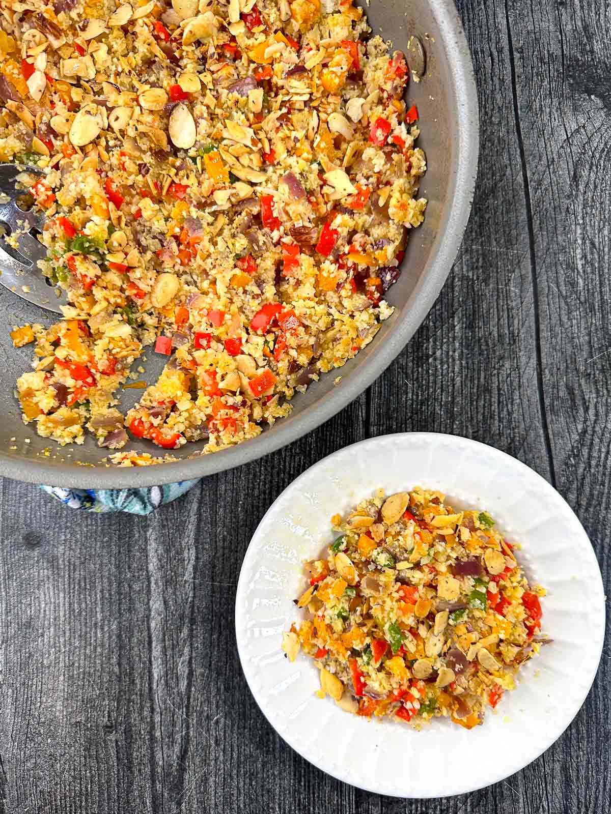 white plate and pan with keto cauliflower rice pilaf with peppers