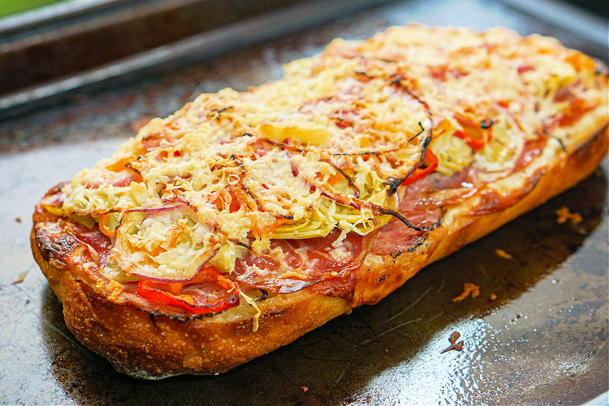 baking tray with cooked antipasto pizza on French bread that was baked