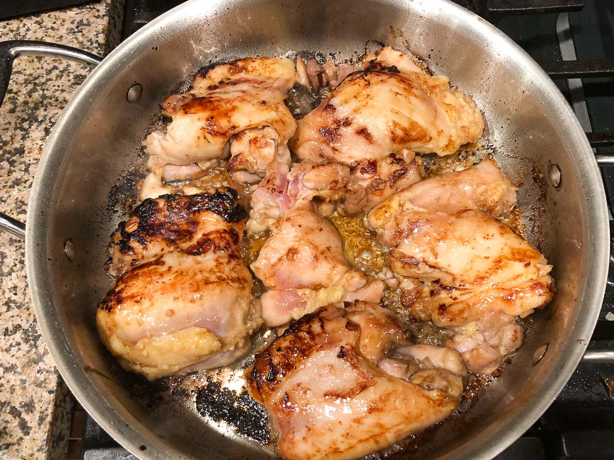 pan with browned chicken thighs