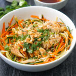 big bowl of Asian noodles salad with fresh cilantro and a bowl of dressing and text