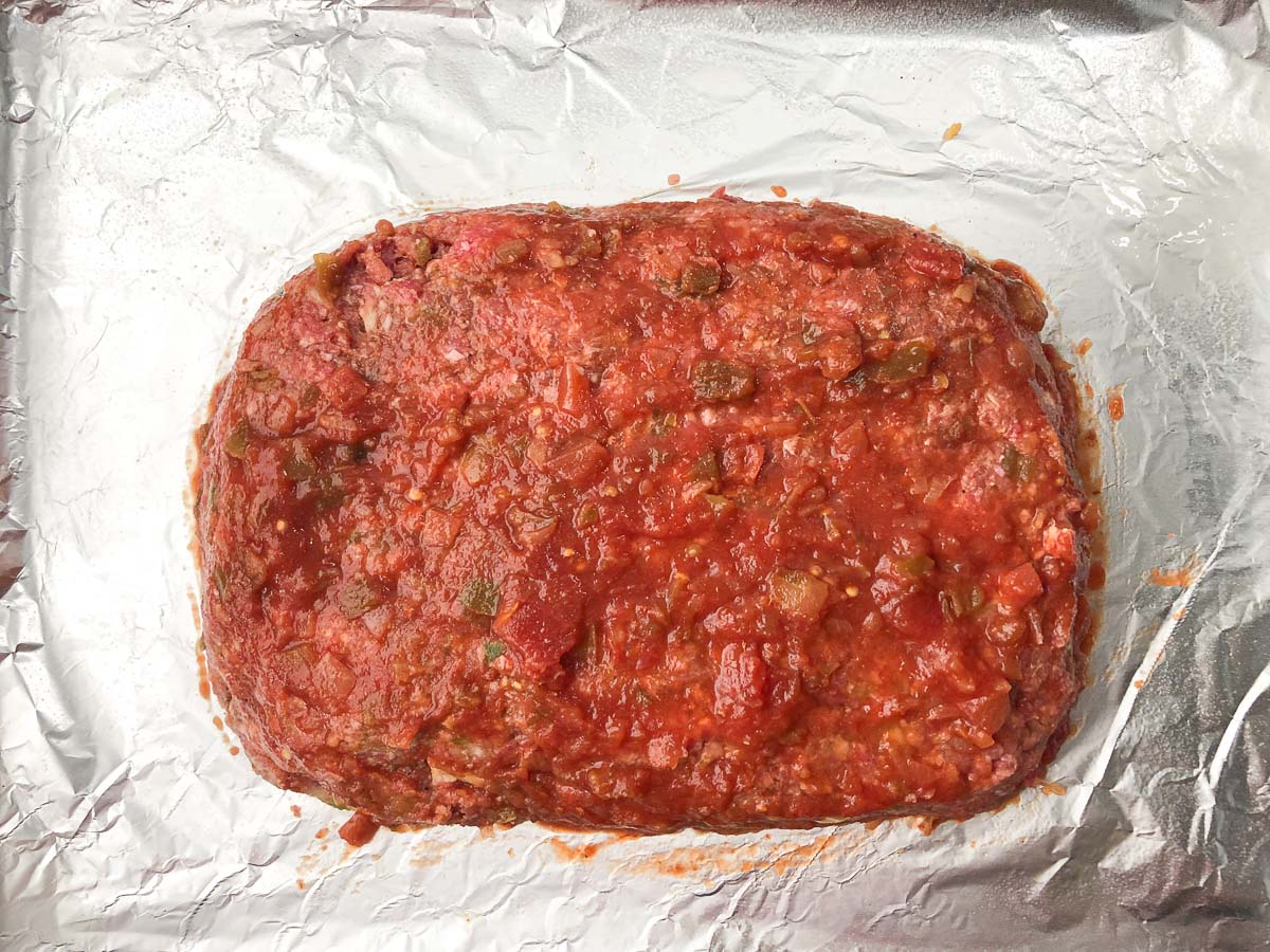foil covered baking dish with prepared mexican meatloaf ready to bake