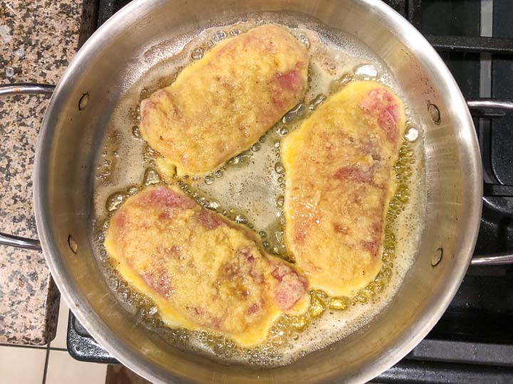 cooking the pork chops in a pan on the stove