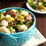 Long photo of blue bowl with Brussels sprouts bacon and cauliflower and text overlay.