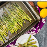 aerial view of a pan of parmesan asparagus with fresh lemons and text