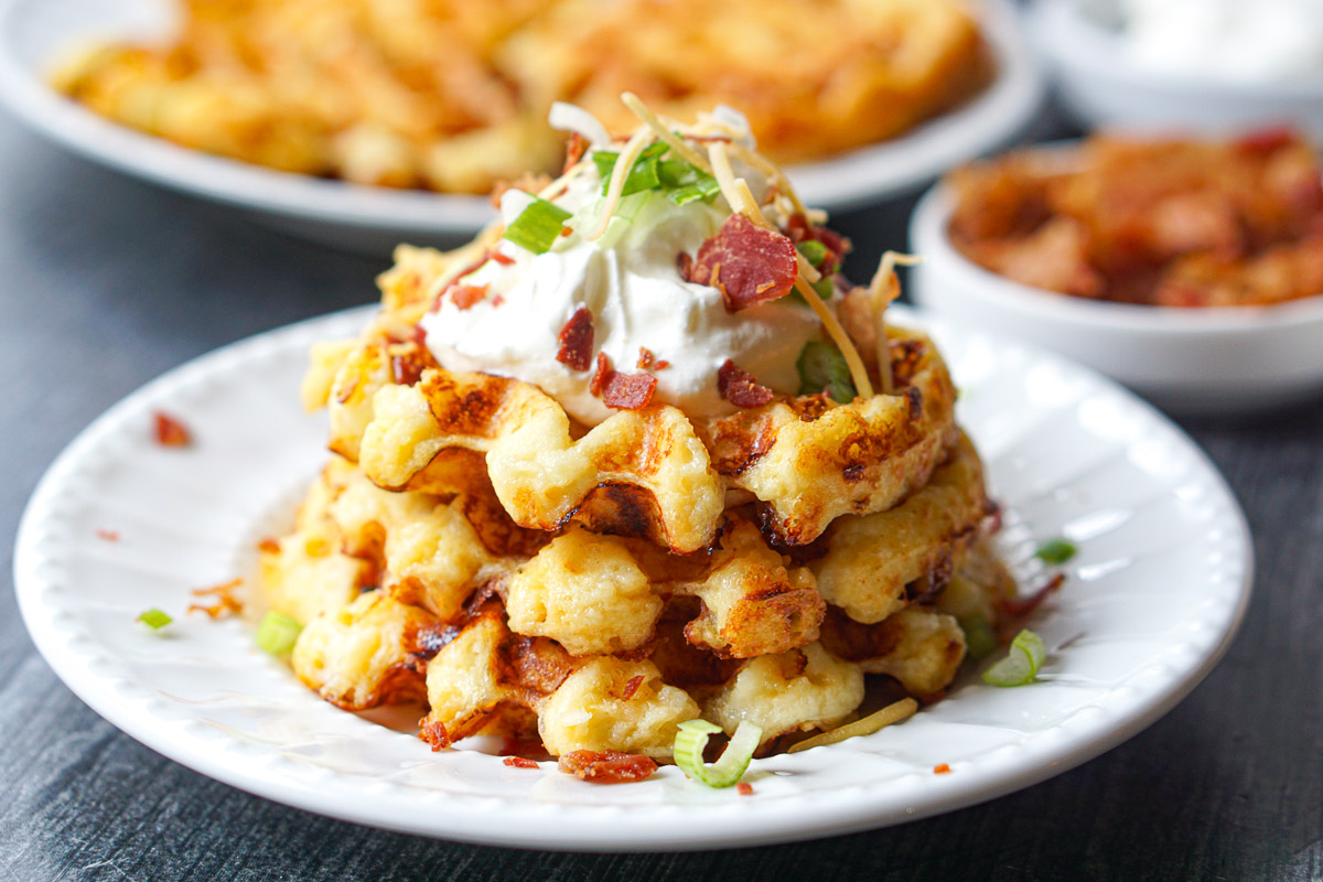 white plate with stack of leftover potato waffles with loaded toppings