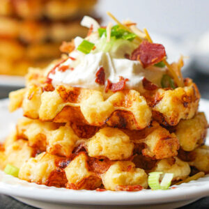 stack of loaded leftover mashed potato waffles on white plate