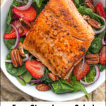 bowl with salmon strawberry spinach salad with text