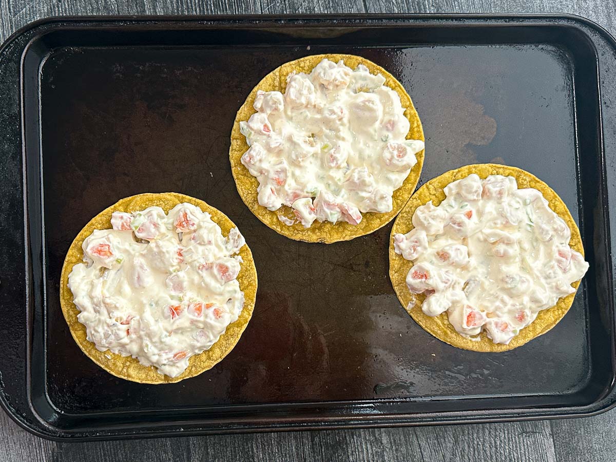 baking sheet with 3 tortillas topped with seafood mixture