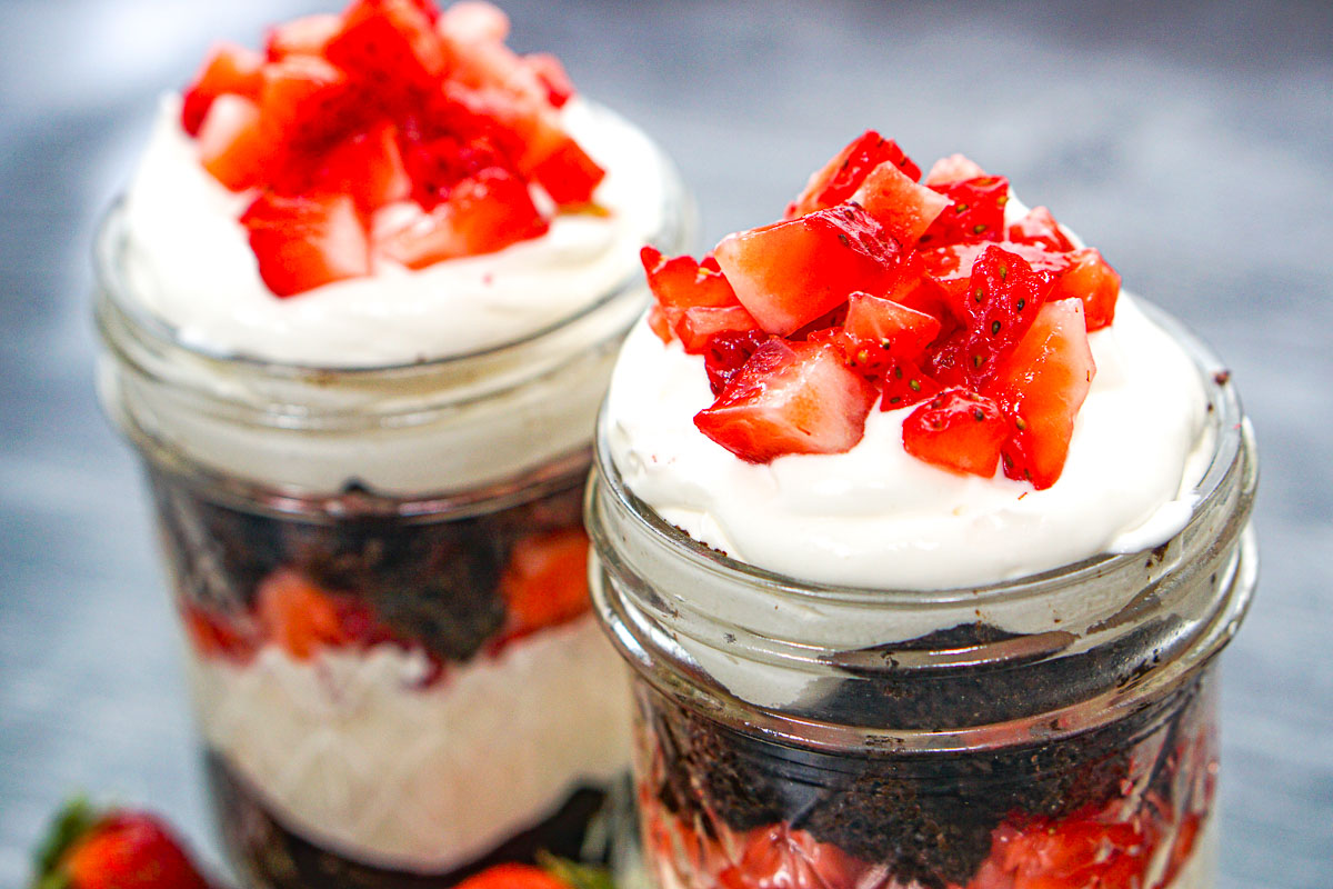 Closeup of the top strawberry layer of the keto cheesecake parfaits with sugar free chocolate cake.