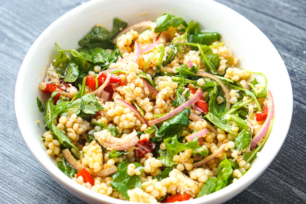 bowl with finished arugula salad with pearl couscous