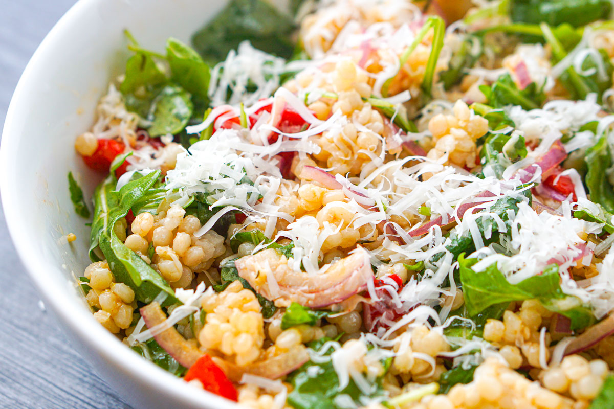 closeup of salad bowl with asiago cheese on top