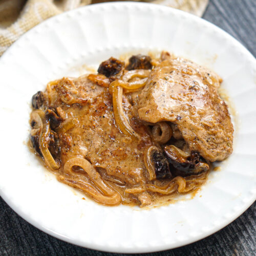 Closeup of a white plate with a serving of pork tenderloin with fig sauce.