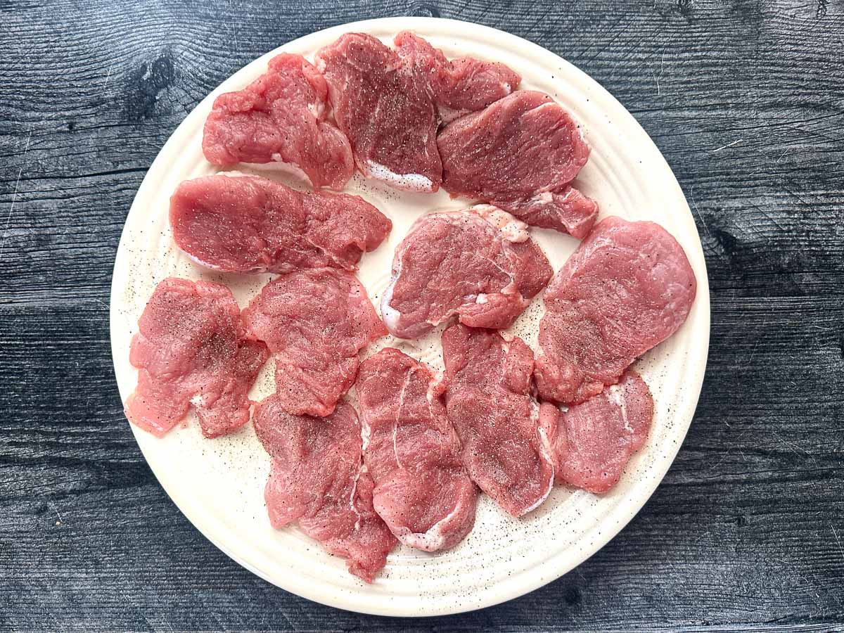 Dish with the raw pork cutlets that were pounded thin.s