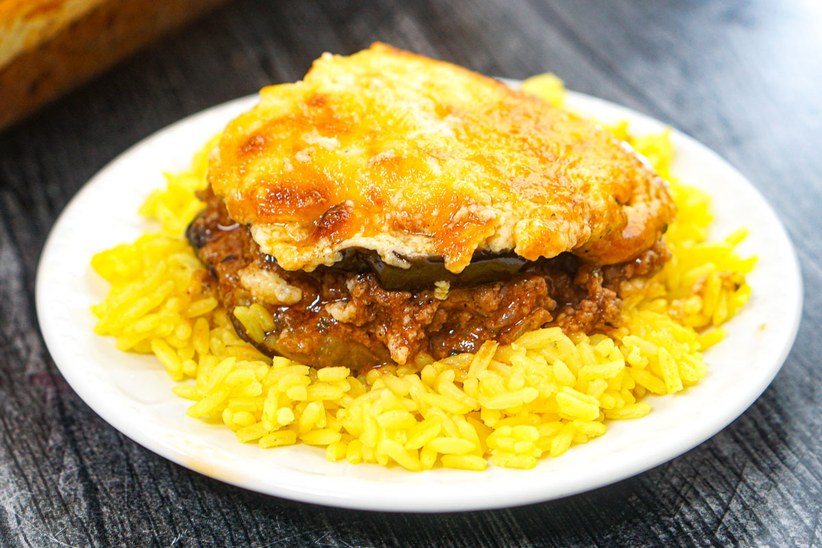 A white plate with a serving of rice and the finished dish.
