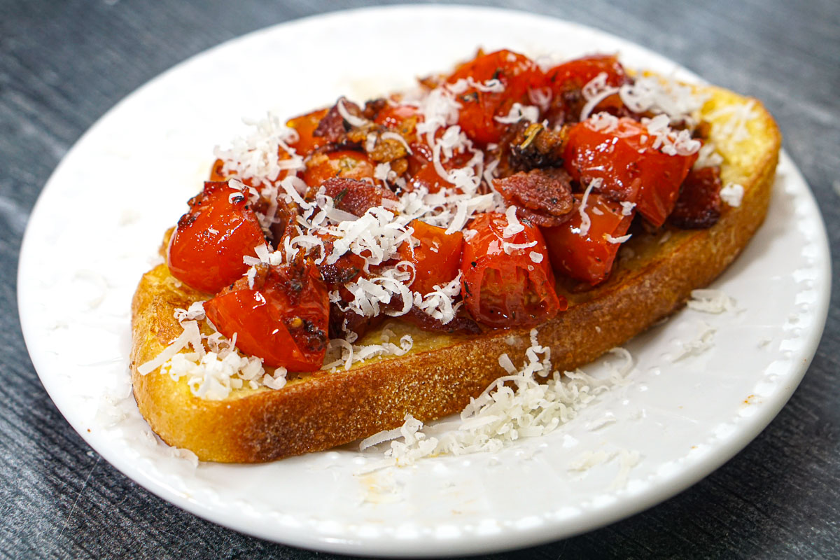 This tomato bacon French toast is a savory change from the usual sweet French toast. A nice and easy dish for breakfast or lunch. White plate with the finished recipe.
