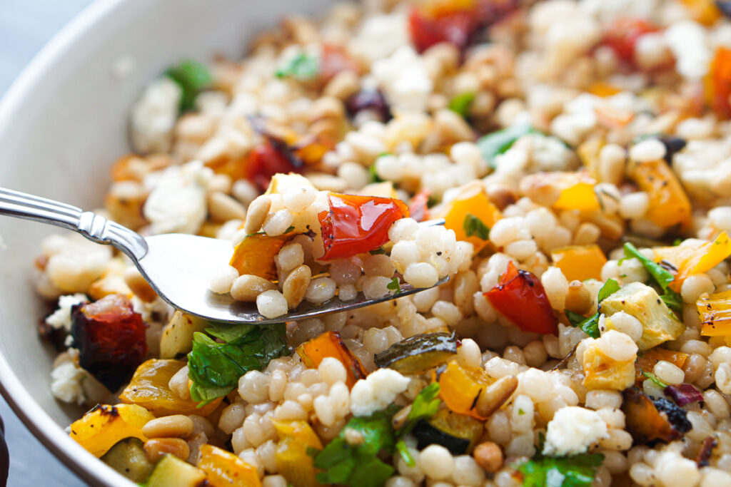 closeup of a fork full of pearl couscous salad
