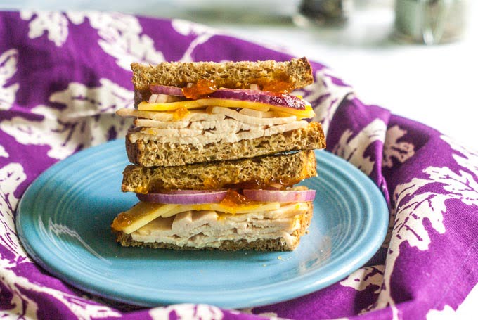  turkey apricot cheddar sandwich on a blue plate with a purple tea towel
