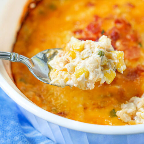 Closeup of a spoonful of hot cream cheese corn dip with bacon.