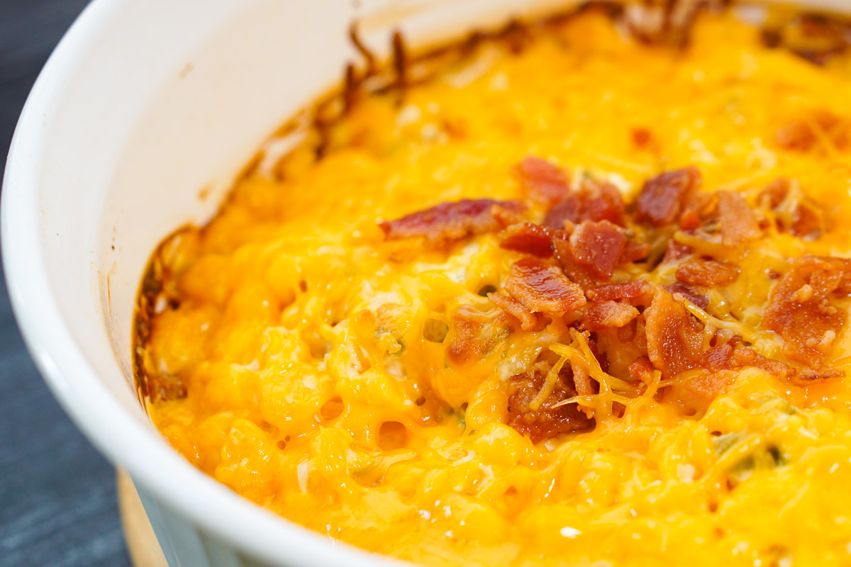 closeup of finished baked corn dip with bacon bits on top