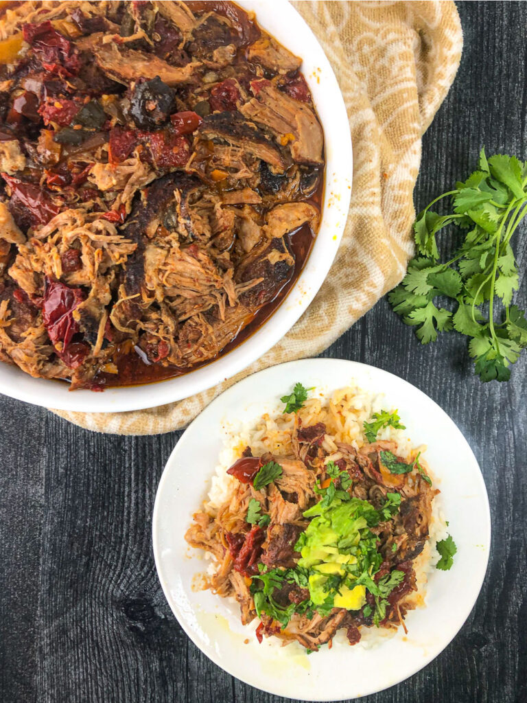 white bowl and plate with slow cooker  shredded pork with avocado and cilantro