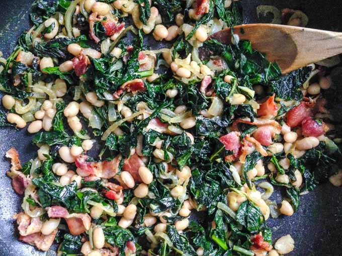 These easy bacon beans & greens are the perfect way to use greens from your garden. Serve as a hearty side dish or as a main course. #SundaySupper