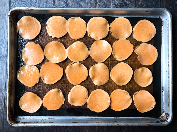 sweet potato chips on a cookie sheet ready to be baked