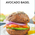closeup of a smoked salmon avocado bagel sandwich with text