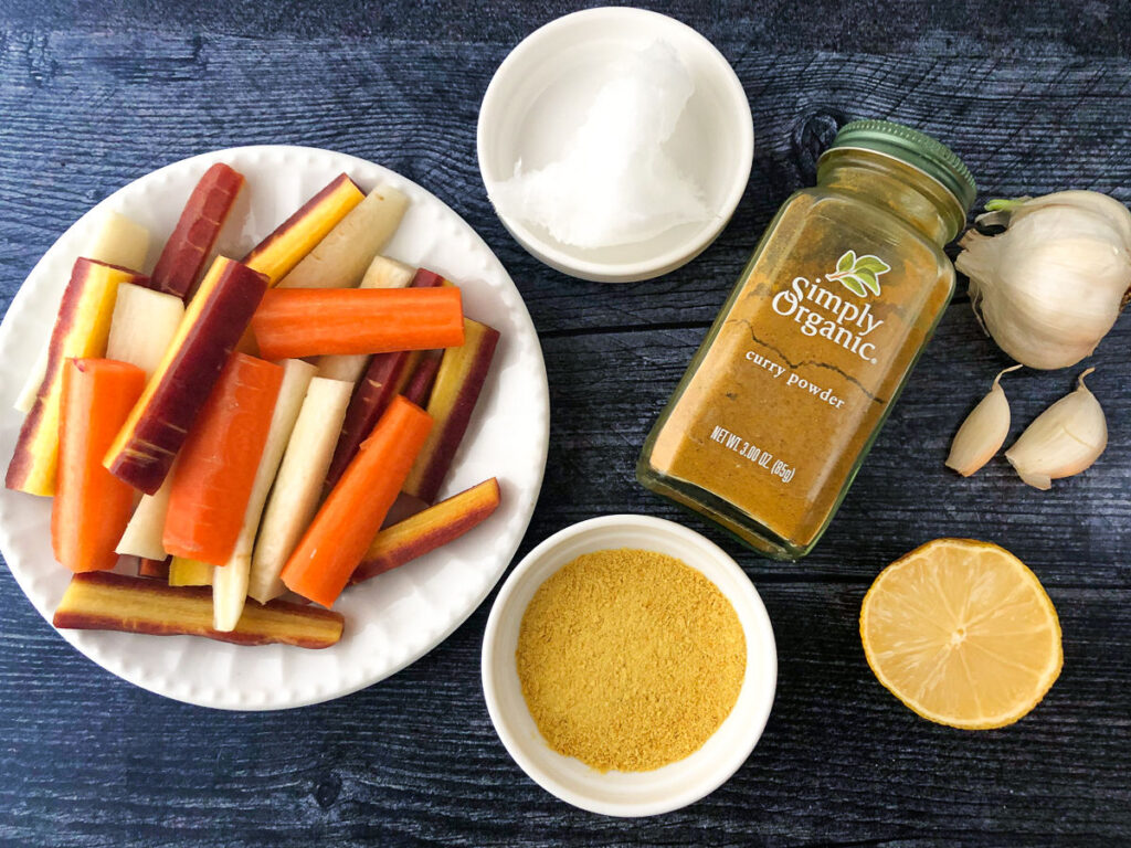 roasted curry carrots ingredients - cut carrots, coconut oil curry spice, nutritional yeast, garlic and lemon