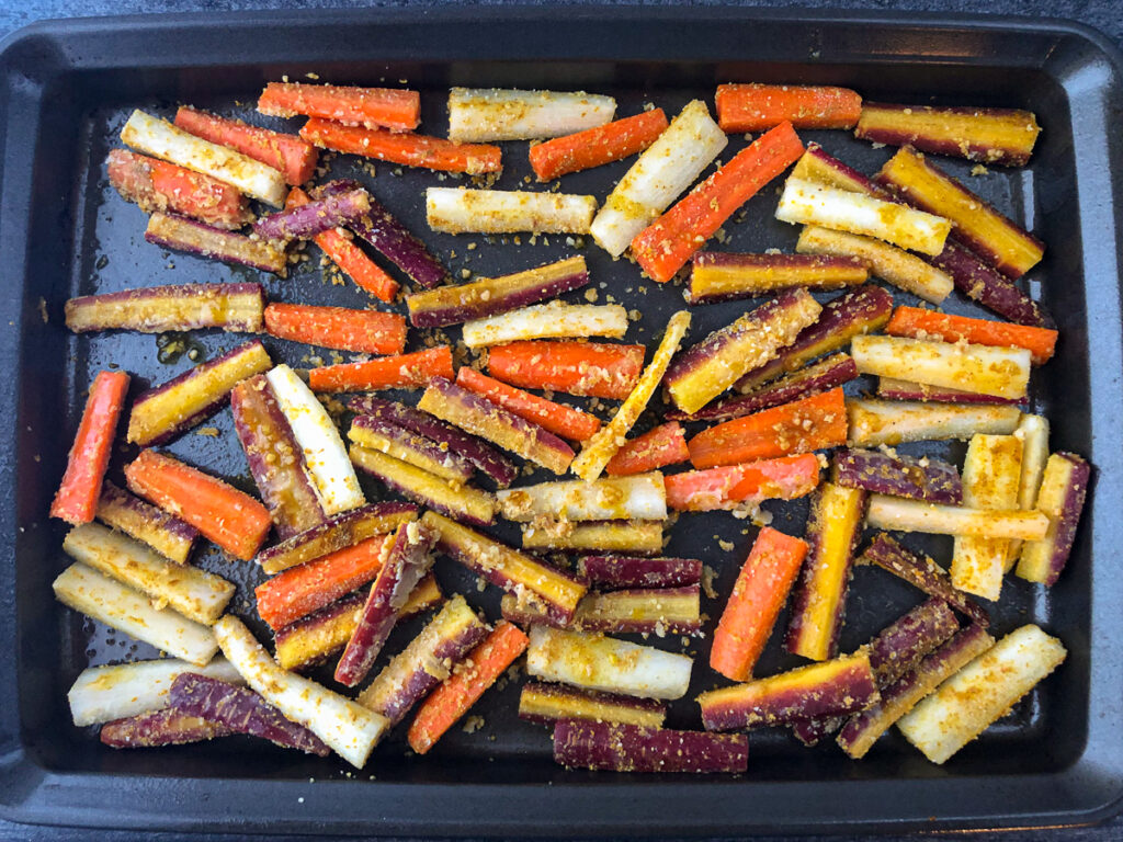 baking tray with raw carrots ready to bake