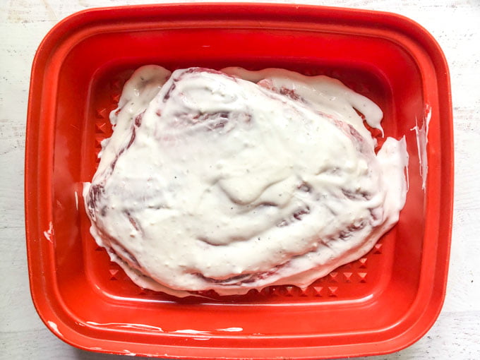 blue cheese marinated flanks steak in red container