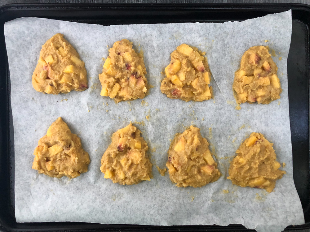 cookie sheet with raw scone dough on a piece of parchment paper