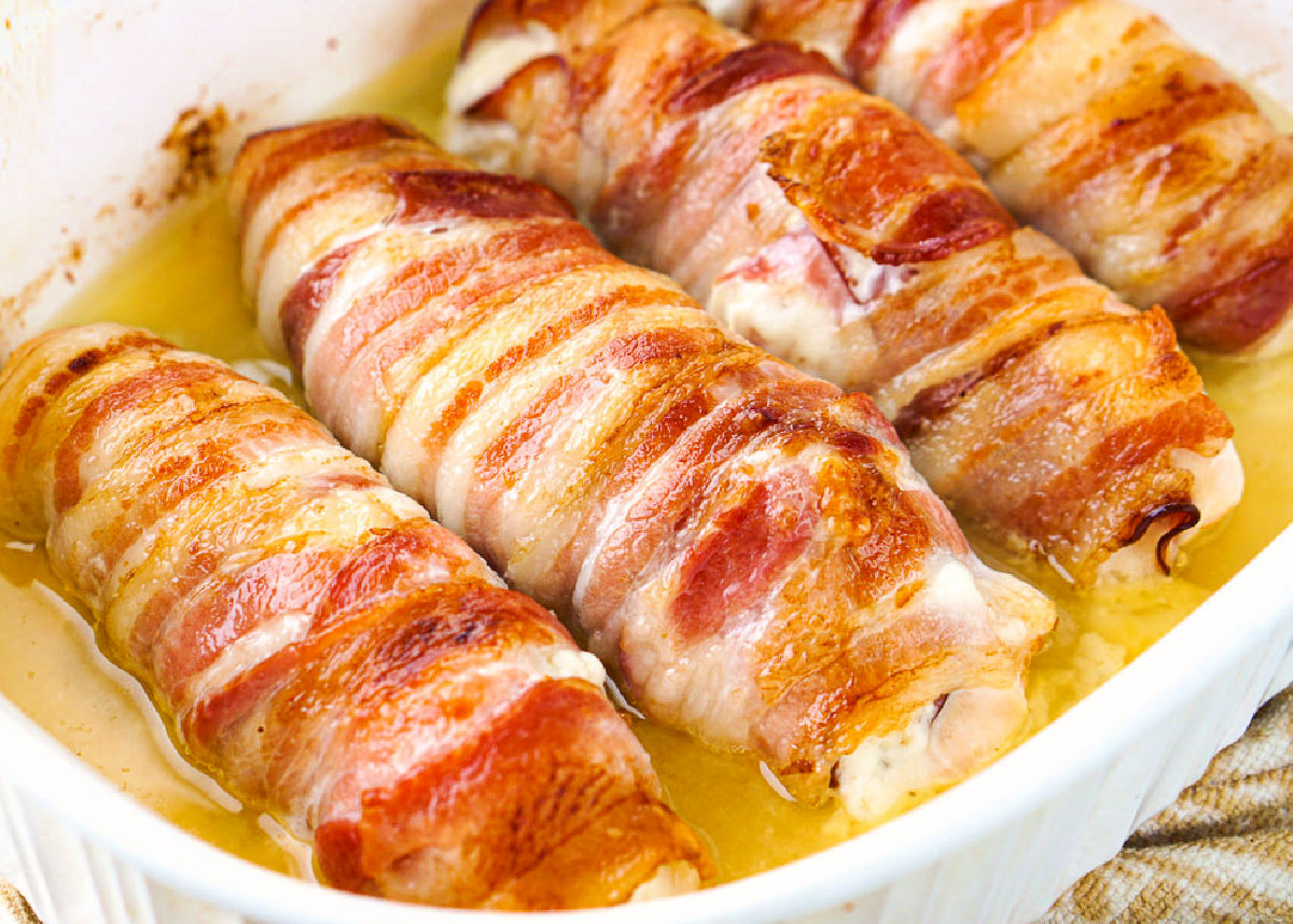 closeup of baking dish with 4 pieces of bacon wrapped chicken breast