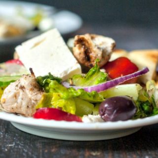 This easy Greek chicken salad is filled with tasty Mediterranean goodies and topped with chicken kebabs. Serve with pita bread for a light but tasty dinner.