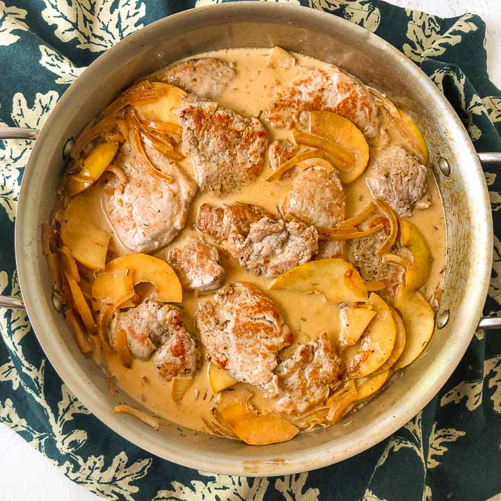 pan with low carb pork tenderloin and apples dish and a green tea towel underneath