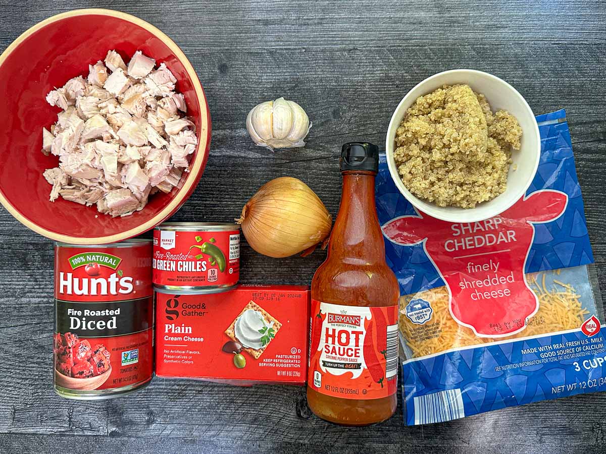 recipe ingredients chicken, quinoa, garlic, onion, tomatoes, chilis, creamy cheese, cheddar and hot sauce