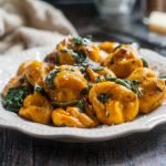 These gluten free butternut tots are half tot and half gnocchi and 100% delicious. Topped with browned butter, spinach and freshly grated asiago cheese for a delicious vegetarian meal.