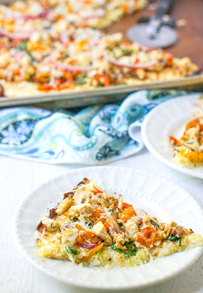 white plate with chicken and vegetable pizza slices