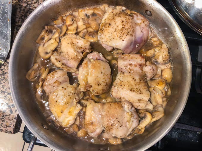 pan on the stove with chicken and mushrooms sautéing 