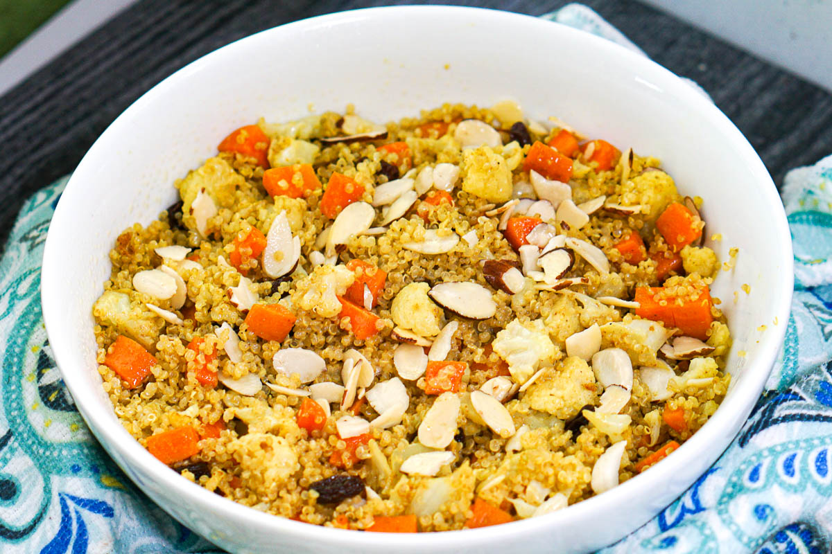 bowl with finished vegetable quinoa curry with nuts on top