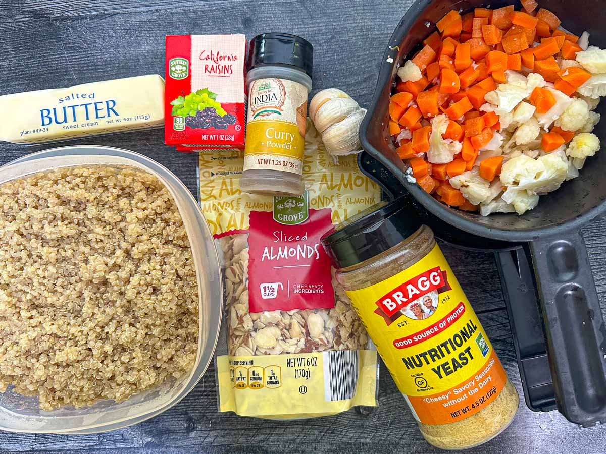 recipe ingredients - quinoa, butter, raisins, curry powder, garlic, almonds, veggies and nutritional yeast