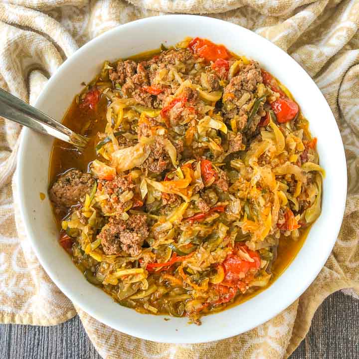 white bowl with slow cooker veggie spaghetti with a beige tea towel underneath