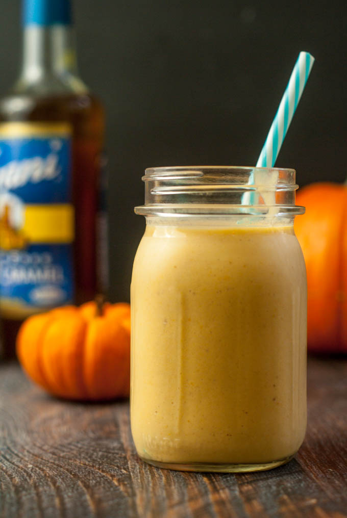low carb protein smoothie in mason. jar with Torani syrup in background and pumpkins
