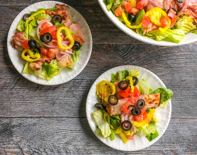 white plates and bowl with low carb Italian sub salad
