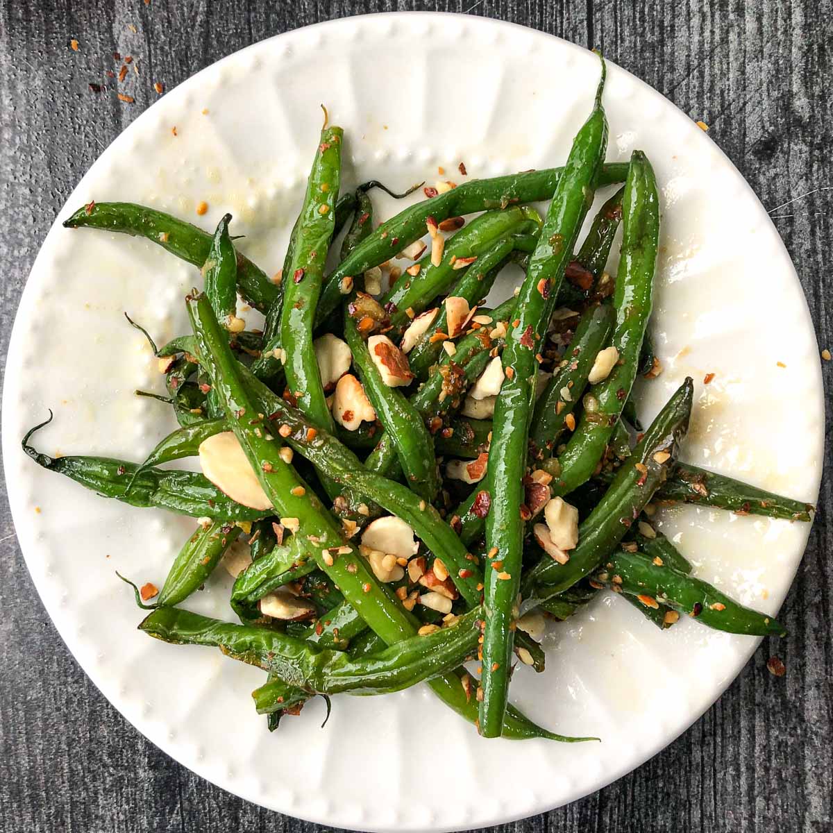 white plate with keto Asian green beans with sliced almonds