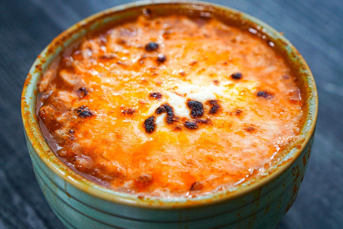 Closeup of a the bowl or low carb lasagna soup with the melted cheese on top.