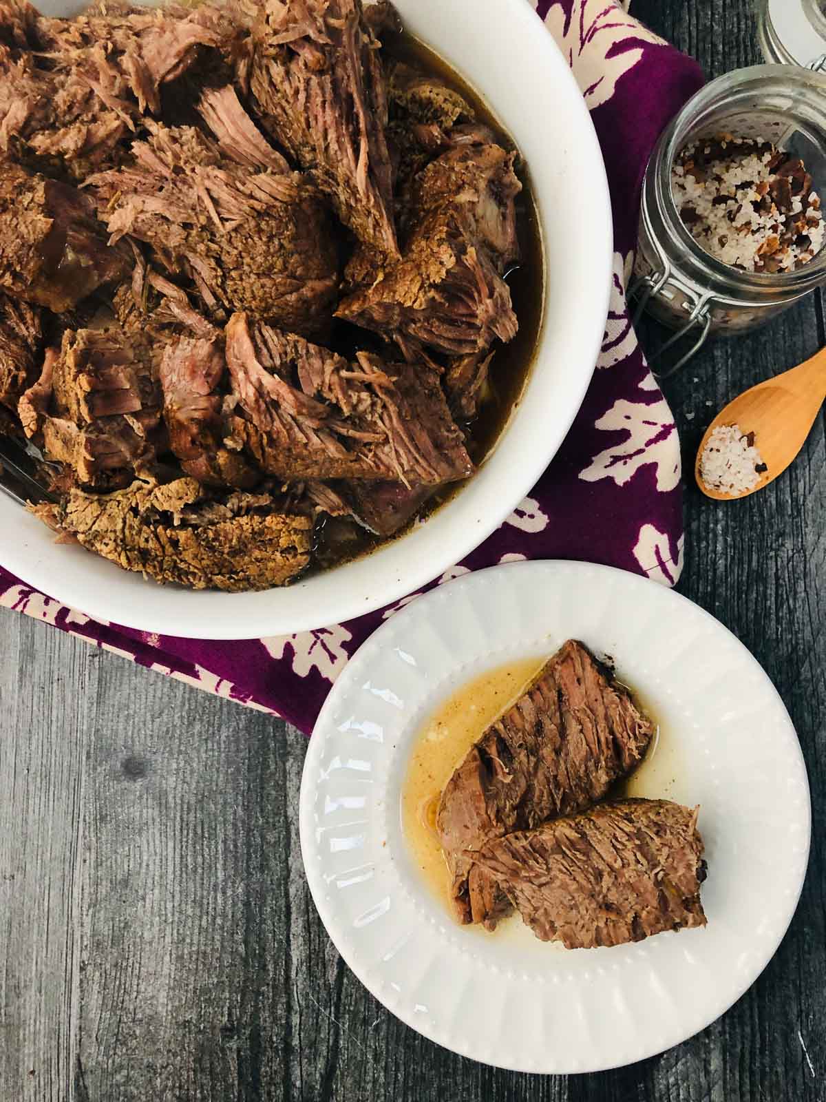 aerial view of a white bowl and plate with balsamic beef made in pressure cooker