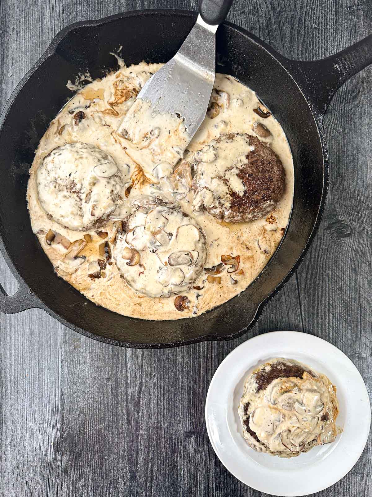 aerial view of pan and plate with burgers in creamy cheese and mushroom sauce