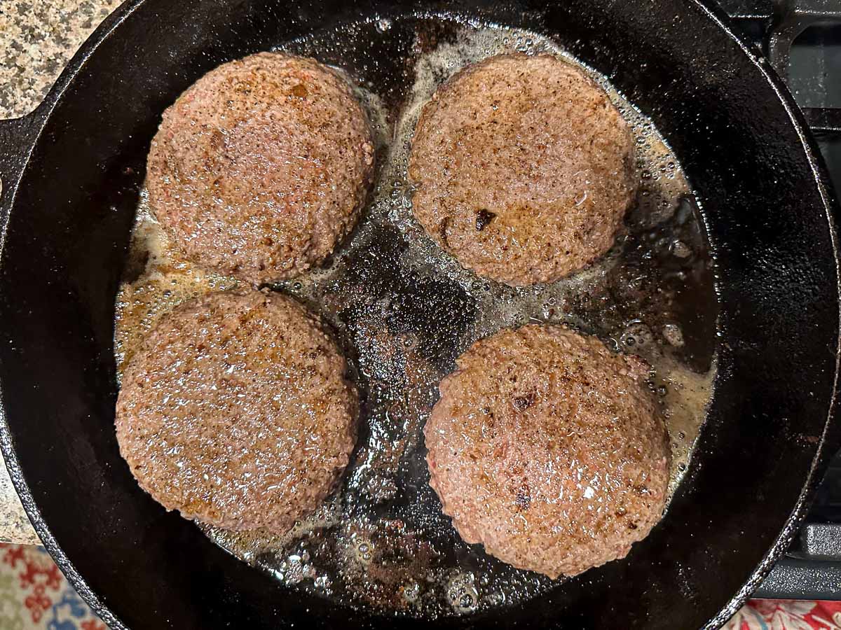 cast iron skillet with 4 burgers
