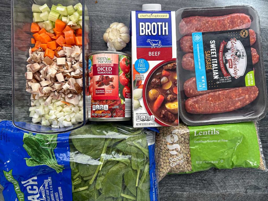 recipe ingredients - chopped veggies, sausage, spinach, lentils, garlic, canned tomatoes and broth
