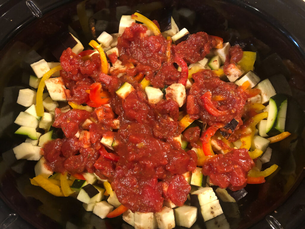 crockpot with veggies on chicken and tomato sauce